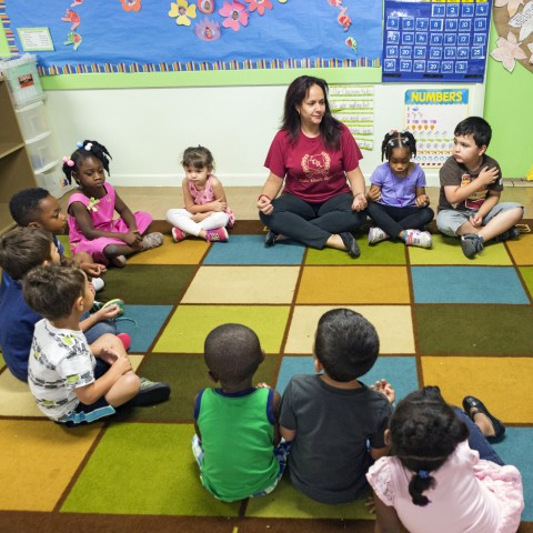 Child care teachers and children sitting in a circle