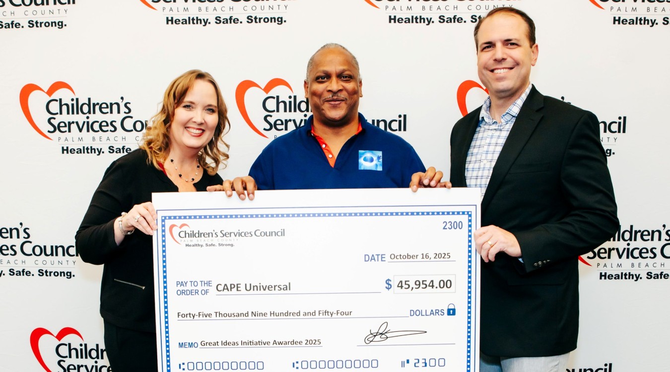 CSC CEO Lisa Williams-Taylor and Board Chair Thomas Bean stand in front of CSC's step-and-repeat sign with a Great Ideas Initiative recipient holding an oversized check during the October 2025 celebration.