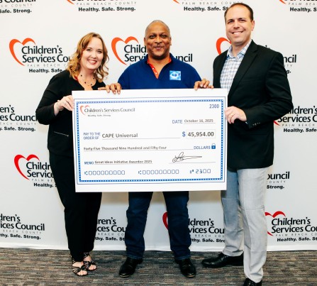 CSC CEO Lisa Williams-Taylor and Board Chair Thomas Bean stand in front of CSC's step-and-repeat sign with a Great Ideas Initiative recipient holding an oversized check during the October 2025 celebration.